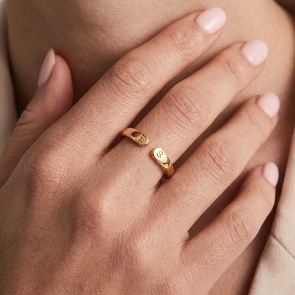Bague initiale dorée portée, initiales gravées visibles sur le dessus de l'anneau