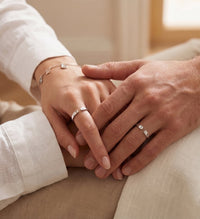 Couple main dans la main portant des bagues initiales personnalisées argentées