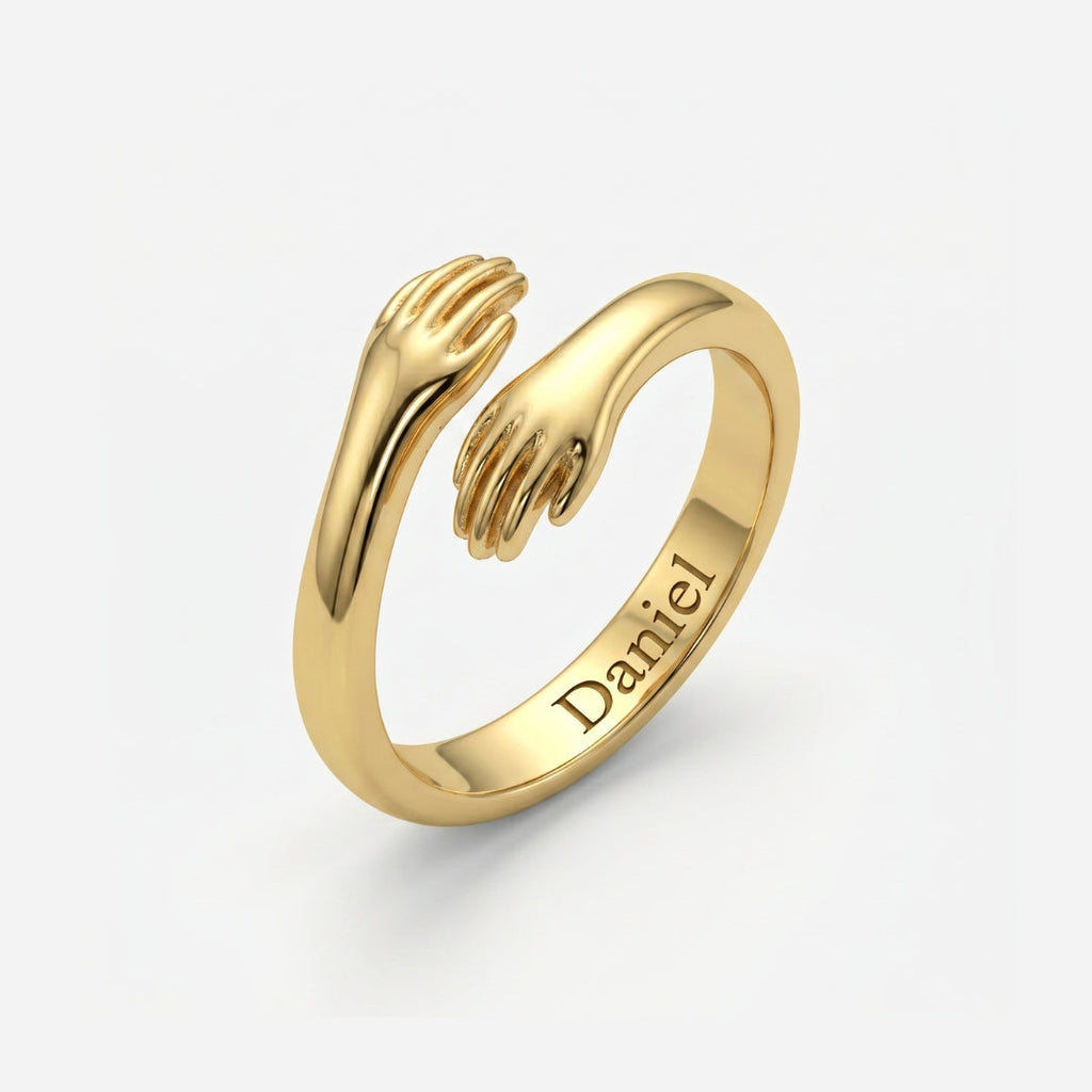Bague câlin personnalisée dorée, deux mains qui s'enlacent et prénom Daniel gravé à l'intérieur