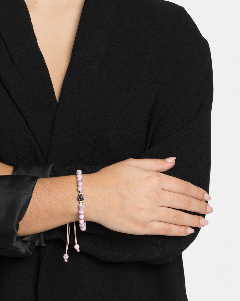 Bracelet photo personnalisé en pierre naturelle Pétale rose porté au poignet d'une femme