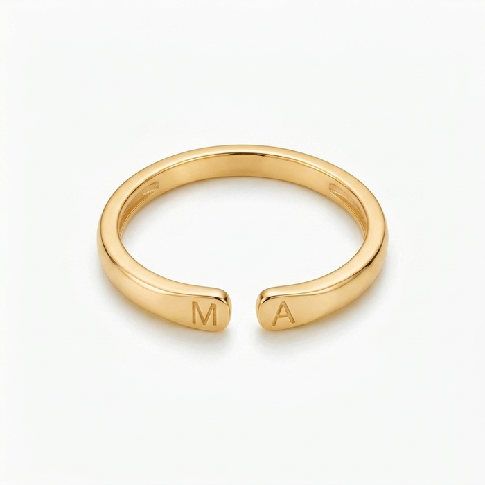 Bague avec initiale dorée vue de face, lettres M et A gravées de chaque côté de l'ouverture