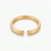 Bague avec initiale dorée vue de face, lettres M et A gravées de chaque côté de l'ouverture