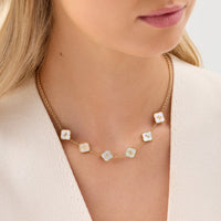 Collier trèfle nacre doré porté au cou, initiales personnalisées sur six trèfles en nacre