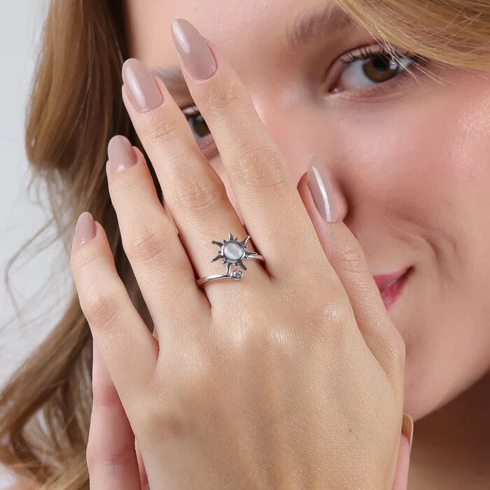 Bague anti-stress Akira argentée portée à la main d'une femme souriante