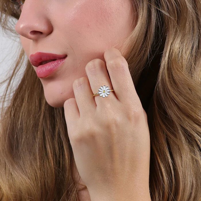 Femme portant la bague anti-stress Marguerite argentée, main contre la joue