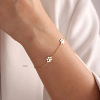 Bracelet patte chien doré porté au poignet - bijou personnalisé amour animal Petale Paris