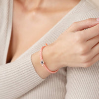 Bracelet tressé rose porté au poignet, bijou photo personnalisé