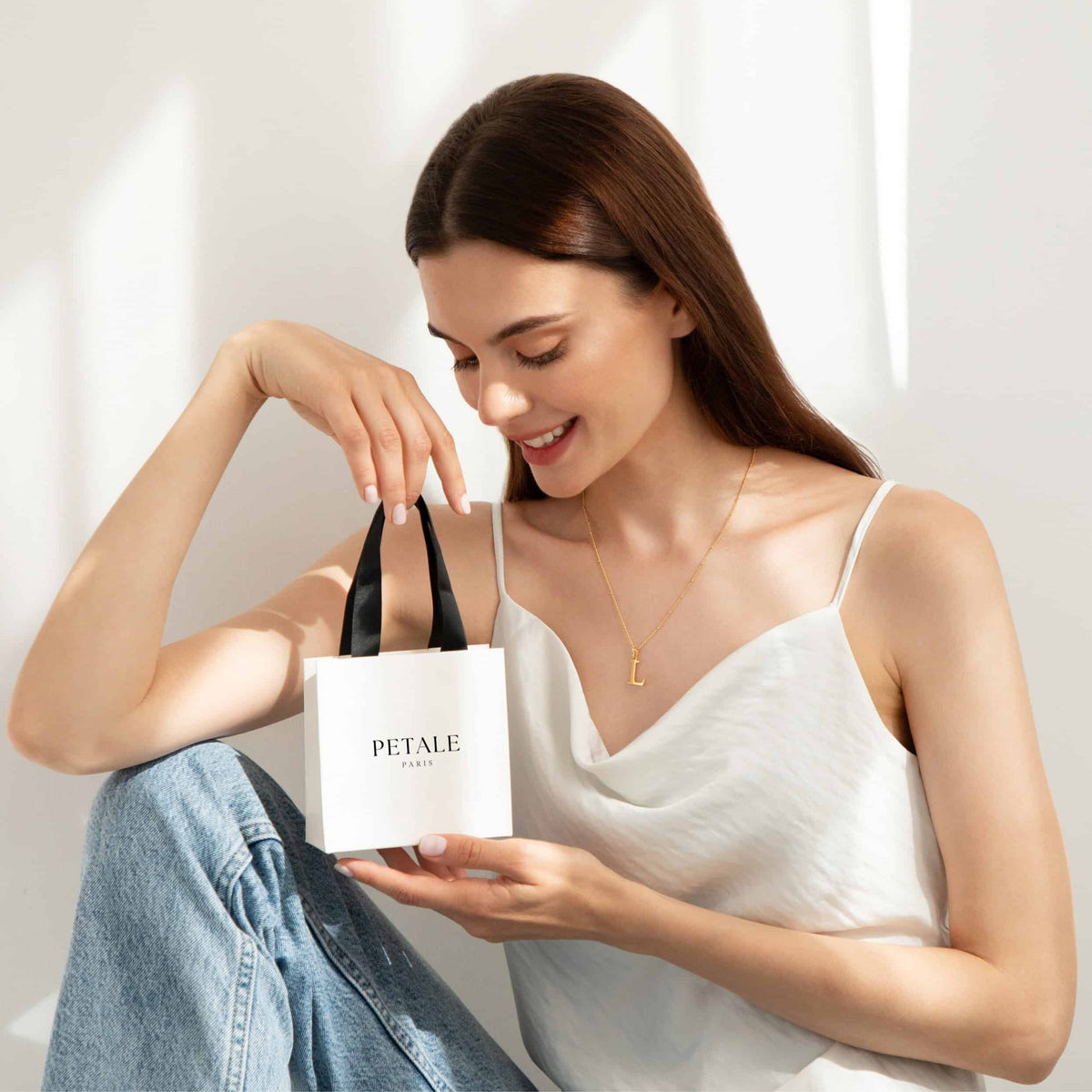 Femme ouvrant le sac du coffret cadeau Petale Paris, bijou prêt à offrir Image