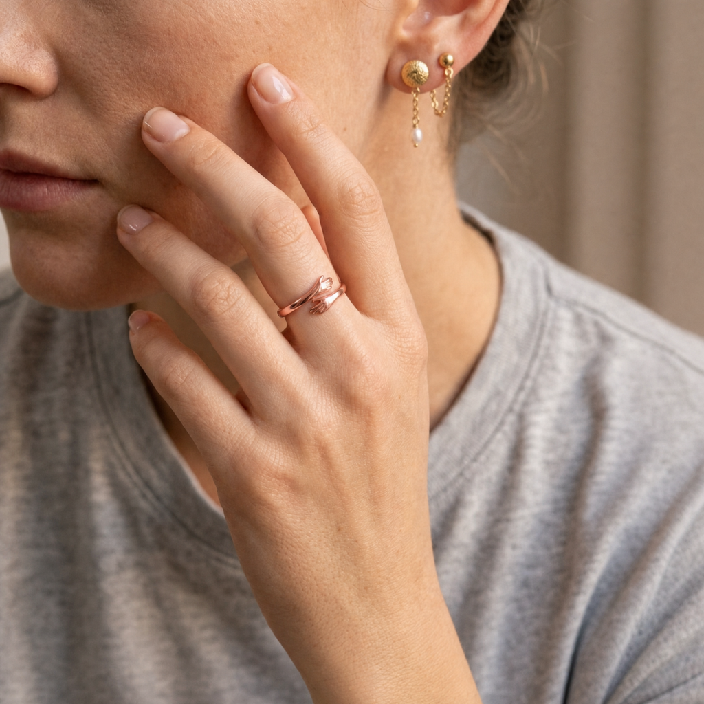 Femme portant la bague câlin or rose, taille ajustable, main contre la joue