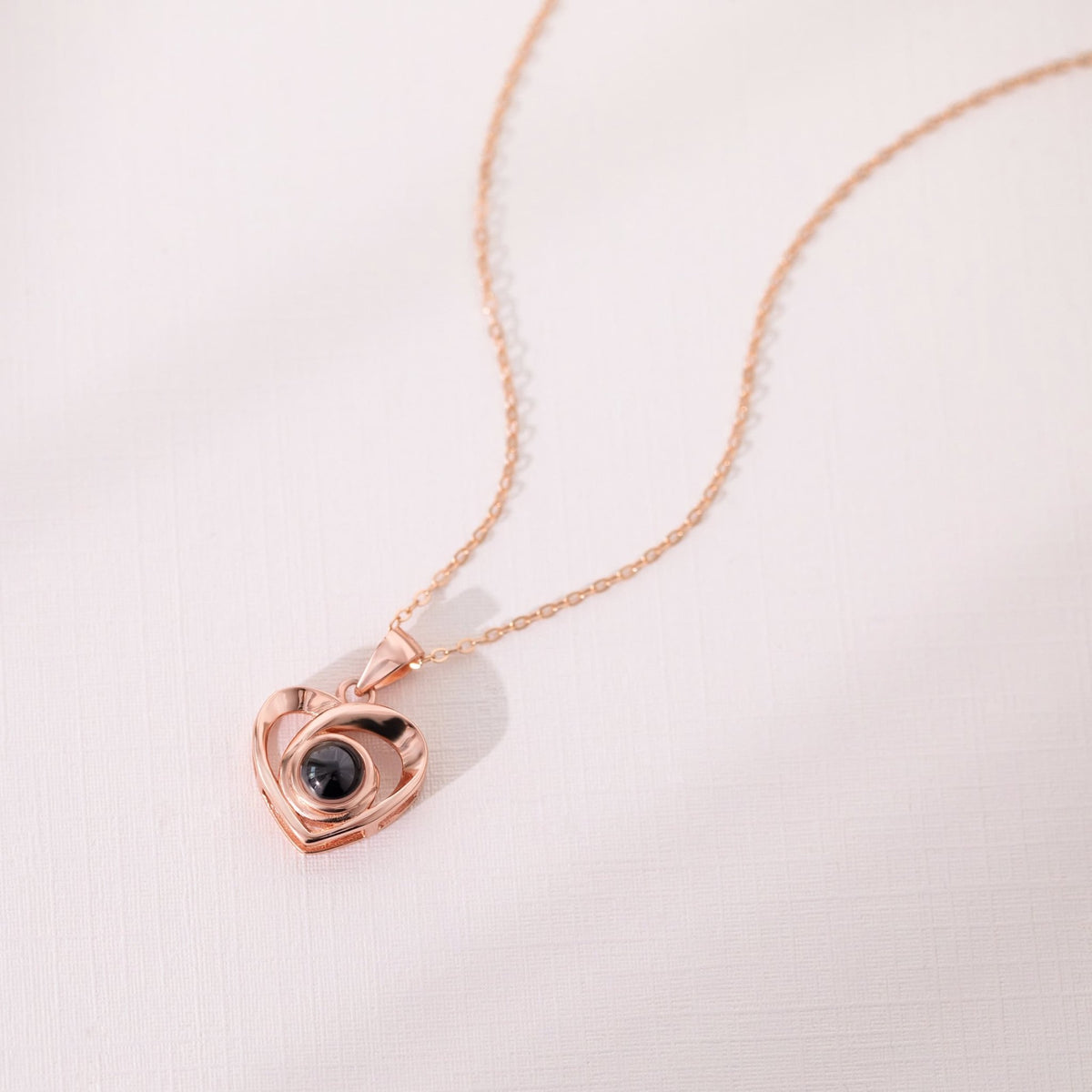 Pendentif cœur or rose à projection photo, gros plan sur lentille et finition