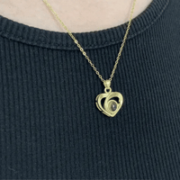 Pendentif cœur photo à projection doré porté sur pull noir