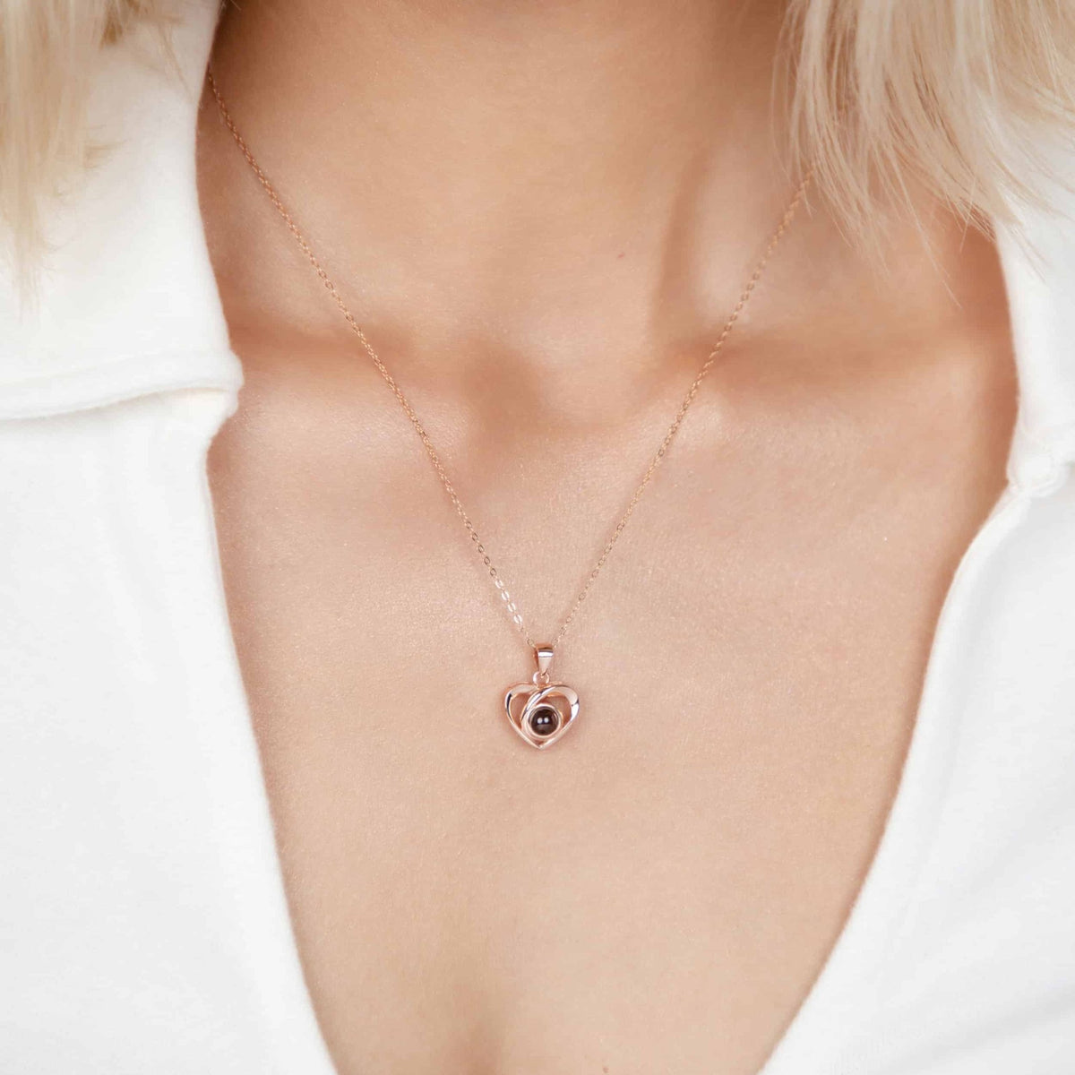 Collier cœur photo personnalisé or rose porté sur chemise blanche, pendentif à projection