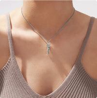 Collier couple enlacé argenté porté sur un débardeur, pendentif câlin discret