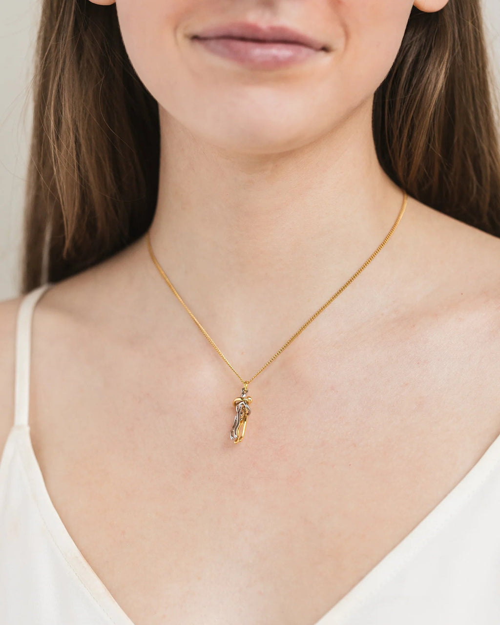 Femme portant le pendentif couple enlacé doré, idée cadeau pour sa moitié